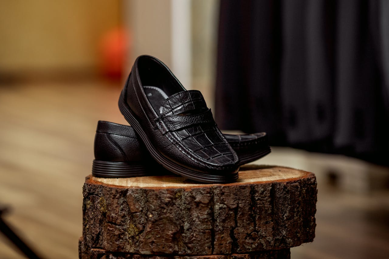 Stylish black loafers displayed on wood, highlighting detailed craftsmanship.